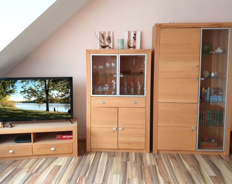 Massivholzschränke mit Glasteilen und Fernseher im Wohnzimmer.